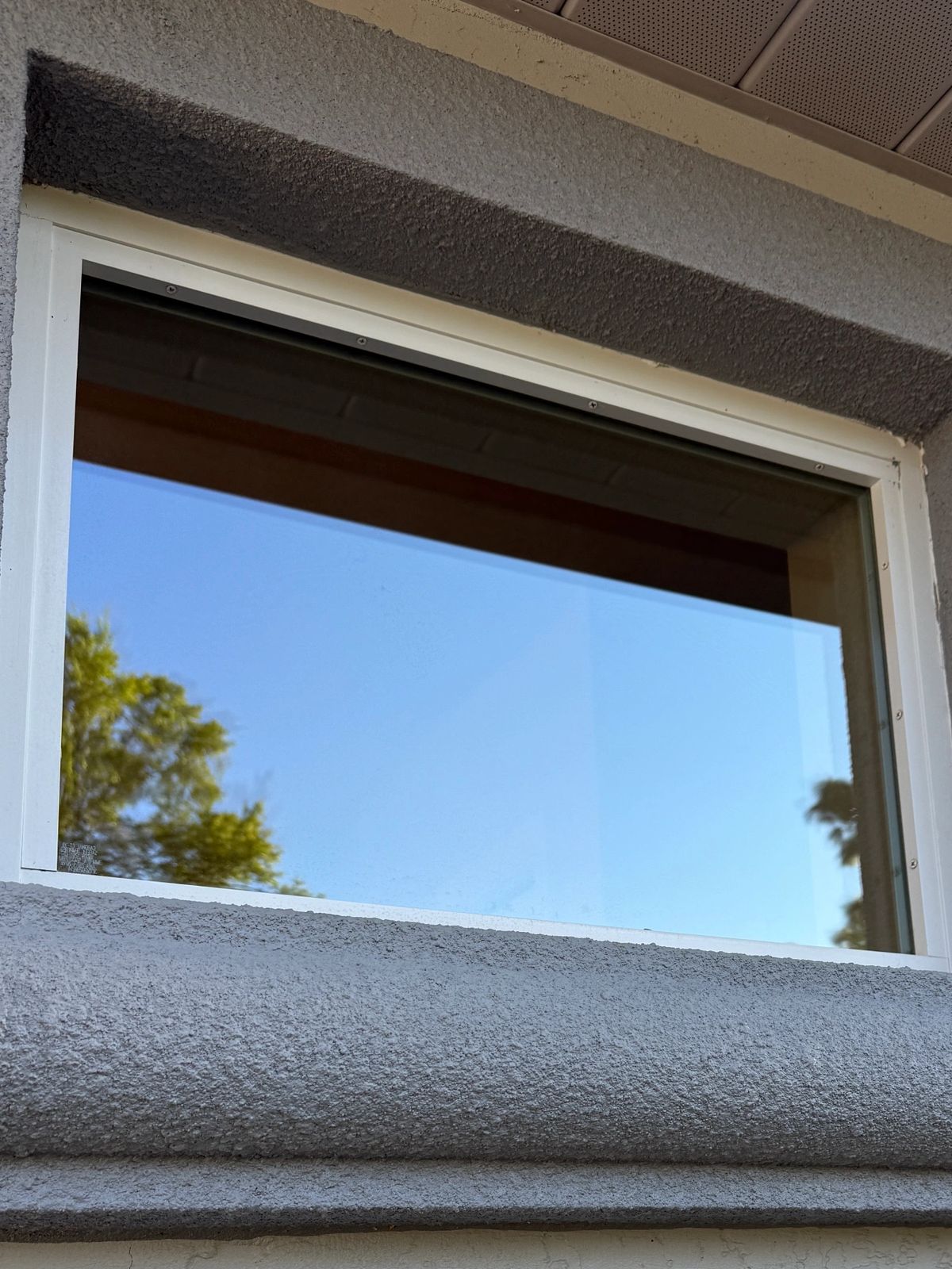 Small exterior window cleaned until the glass disappears against the blue sky