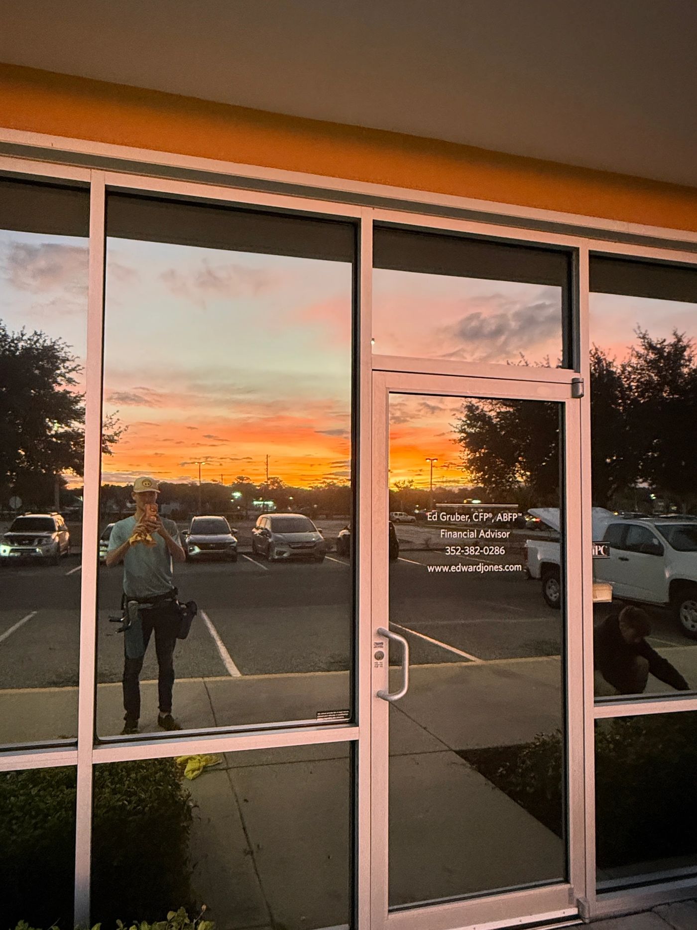 Commercial storefront glass cleaned at sunset, reflecting an orange Florida sky
